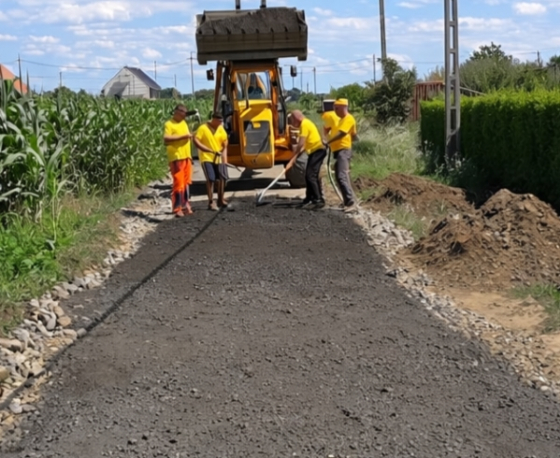 Mart aszfalt bedolgozása gépi erővel.